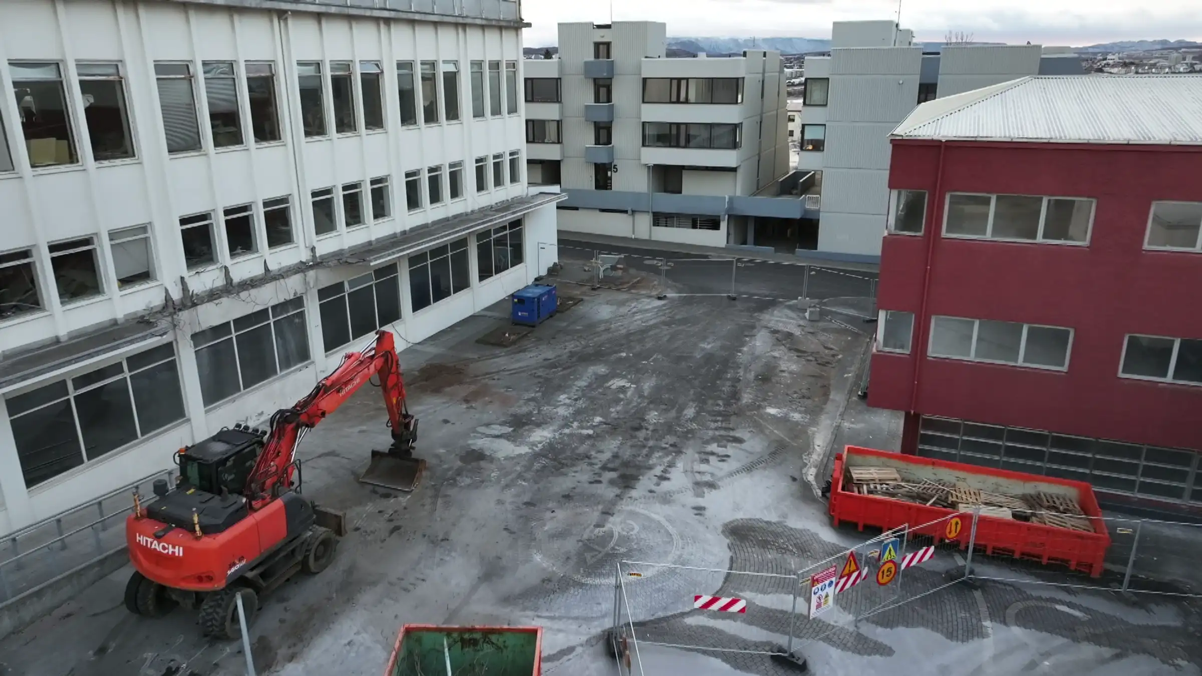 Myndin sýnir til vinstri Fannborg 2 þar sem búið er að rífa part úr þakskyggni byggingarinnar. Á myndinni eru girðingar sem afmarka svæðið og innan þeirra er appelsínugul grafa sem stendur við Fannborg 2 Myndin sýnir til vinstri Fannborg 2 þar sem búið er að rífa part úr þakskyggni byggingarinnar. Á myndinni eru girðingar sem afmarka svæðið og innan þeirra er appelsínugul grafa sem stendur við Fannborg 2