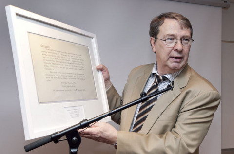 Hrafn A. Harðarson bæjarbókavörður heldur á mynd af dreifibréfi Lestrarfélags Kópavogs.