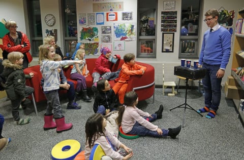 Krakkar fylgjast áhugasöm með Einari einstaka á safnanótt í Bókasafni Kópavogs.