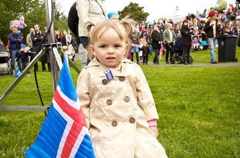 Ung stúlka nýtur blíðunar á Rútstúni þann 17. júní